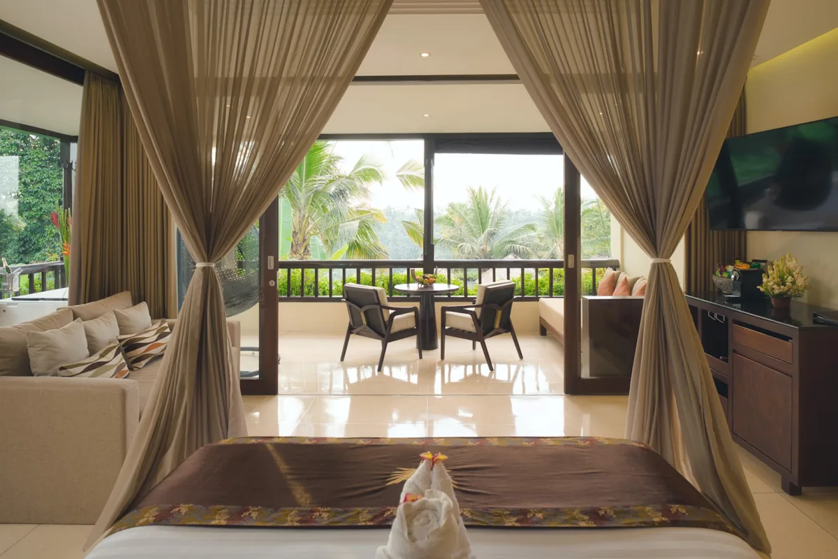 Jungle View Royal Suite with canopy bedroom, living area, and private balcony overlooking the rainforest in Ubud, Bali