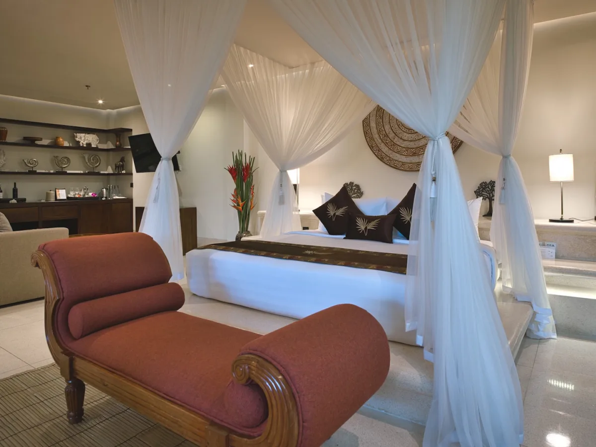 Presidential Royal Suite canopy bedroom with elegant lounge area in Ubud, Bali