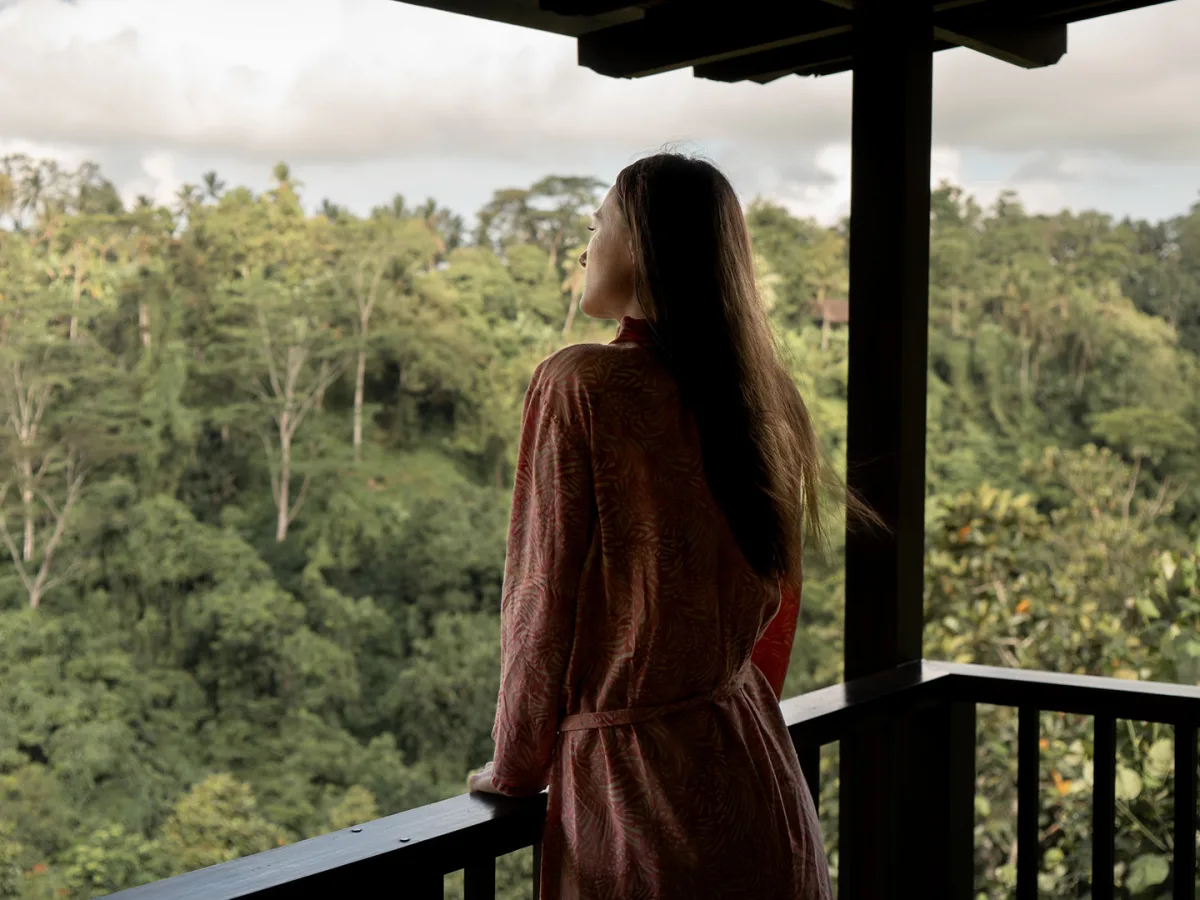 Guest enjoying rainforest views from the private balcony of the Sunrise View Villa in Ubud, Bali